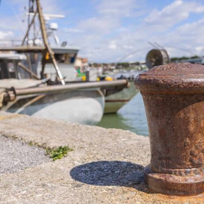Bollard in the harbor, with the background of fishing boats